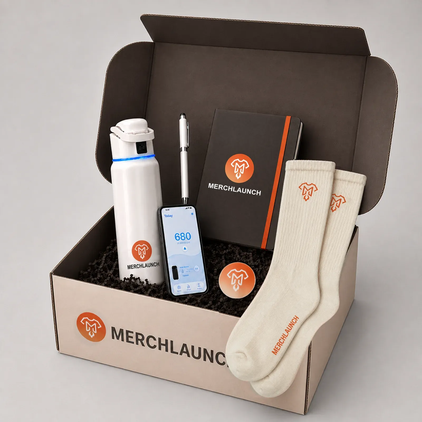 Open MerchLaunch merch kit with a branded notebook, bottle, pen, cream socks, and custom packaging